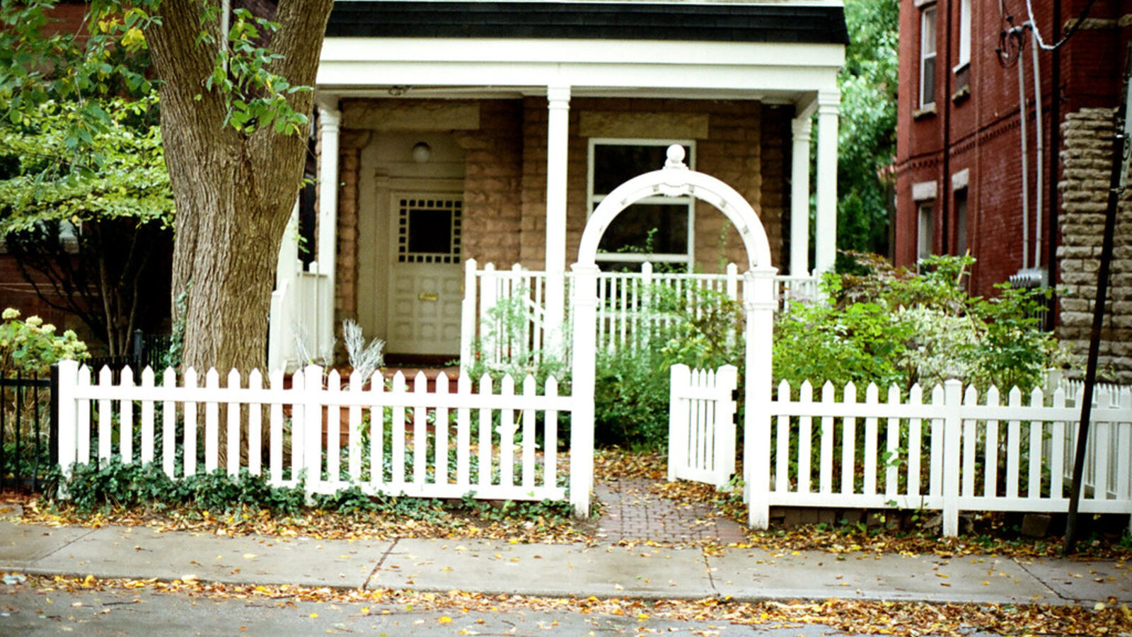 White picket fence and garden gate in front of a house — choosing a front boundary fence